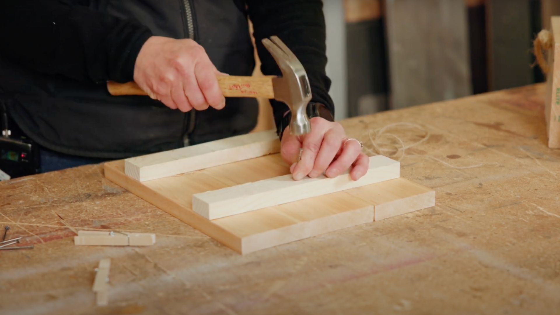 woman hands close up nailing into wood with hammer and nail